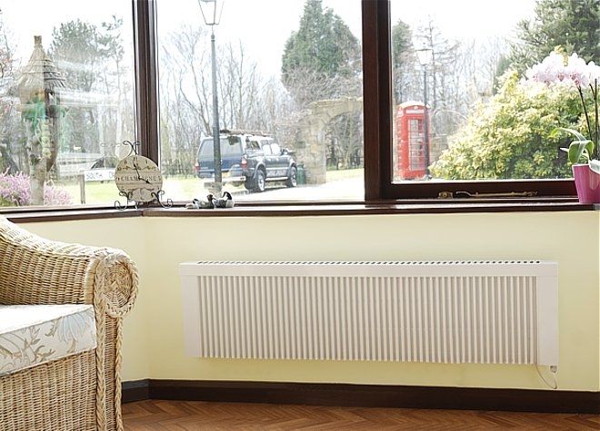 Low height/compact RadTherm electric radiator on a yellow wall